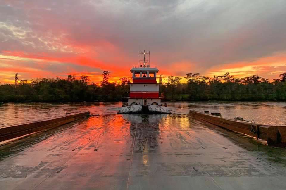 Pere C pushing barges at sunset